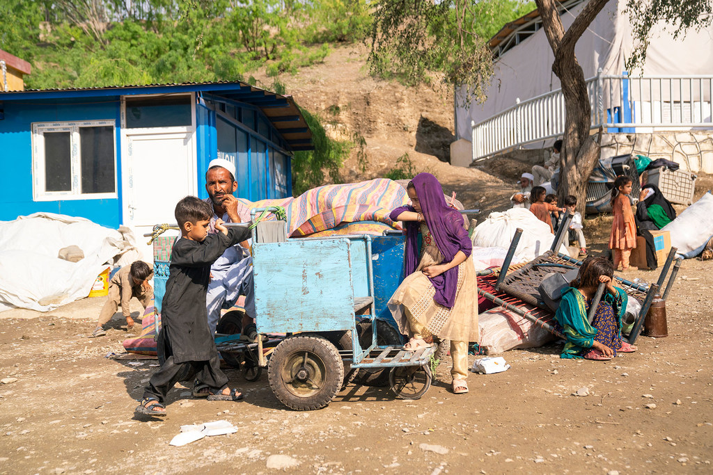 Une famille assise à côté de ses affaires après avoir traversé la frontière vers l'Afghanistan depuis le Pakistan.