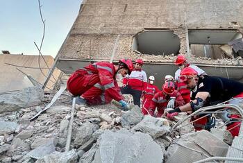 Des bénévoles du Croissant-Rouge iranien fouillent les décombres d'un bâtiment endommagé à Minab, en Iran.
