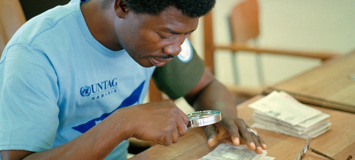 In 1989, a staff member of the UN Transition Assistance Group (UNTAG) checks the validity of a tendered ballot in Namibia. (file)