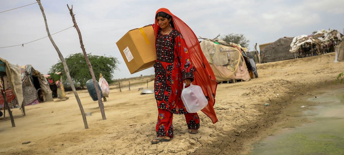 A woman carries humanitarian aid items back to her village in Baluchistan province, Pakistan.