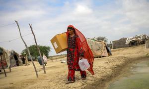 A woman carries humanitarian aid items back to her village in Baluchistan province, Pakistan.
