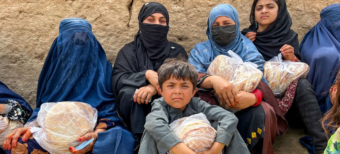 Mujeres y niños con una hogaza de pan en Baghlan, norte de Afganistán.