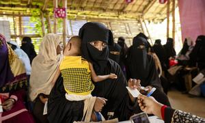 A woman collects monthly a food ration voucher food in a Rohingya refugee camp in Cox's Bazar, Bangladesh. (file)