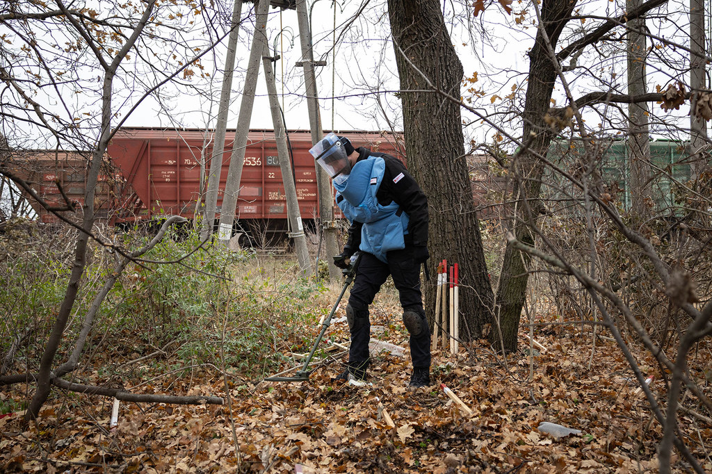 Un démineur procède au déminage d'une zone de combat dans un parc, à la périphérie de la ville de Mykolaïv, en Ukraine.
