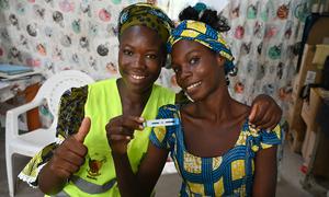 A woman in Moutarwa, Cameroon, holds an HIV test which shows a negative result.