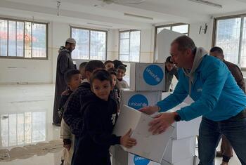 15 दिसंबर, 2025 को गाजा शहर में एक वितरण कार्यक्रम के दौरान यूनिसेफ के एक कार्यकर्ता ने एक बच्चे को सर्दियों के कपड़े की किट सौंपी। किट में जाकीट, जूते, हीटिंग सेट, टी-शर्ट, चप्पल और पैंट शामिल हैं ताकि बच्चों को सर्दियों के दौरान गर्म रहने में मदद मिल सके।