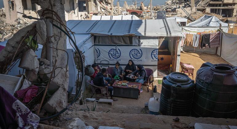 一个巴勒斯坦家庭在加沙的一个临时避难所共享一顿饭,