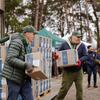 Добровольцы Всемирной продовольственной программы разгружают в Украине коробки продовольственной помощи, помогая семьям переселенцев, пострадавшим от войны.