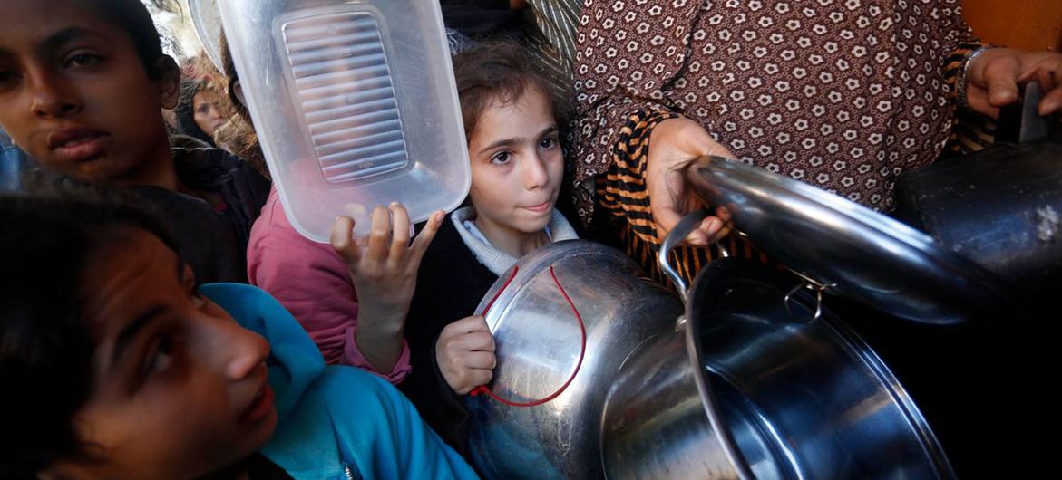 En Deir Al Balah (Gaza), unas familias esperan para recibir alimentos (enero de 2024).