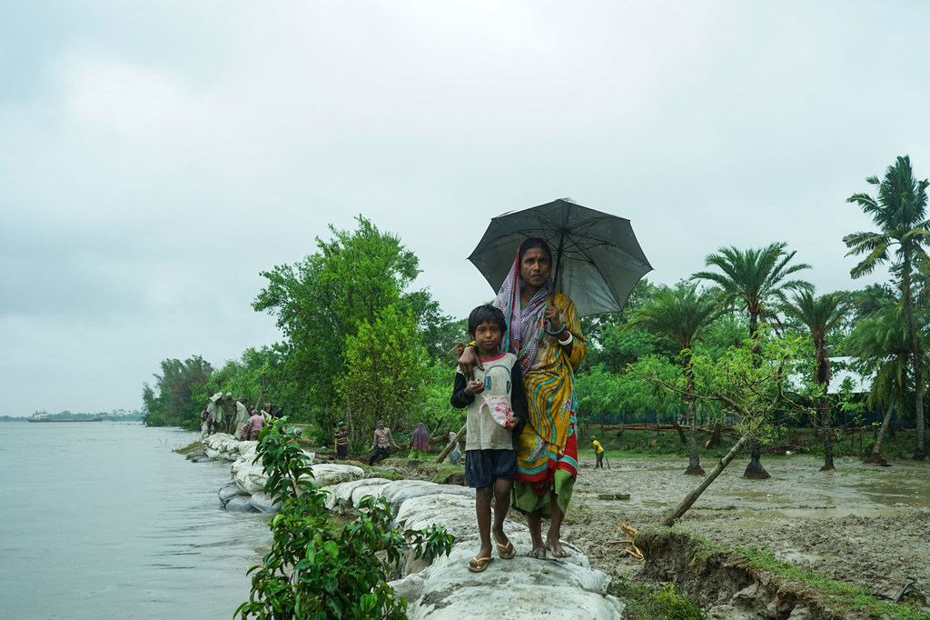 Une femme et un enfant au bord de l'eau au Bangladesh.