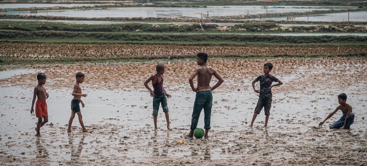Boys play football in a muddy, flooded field in Southern Bangladesh, which was devastated by the Fani cyclone in 2019.