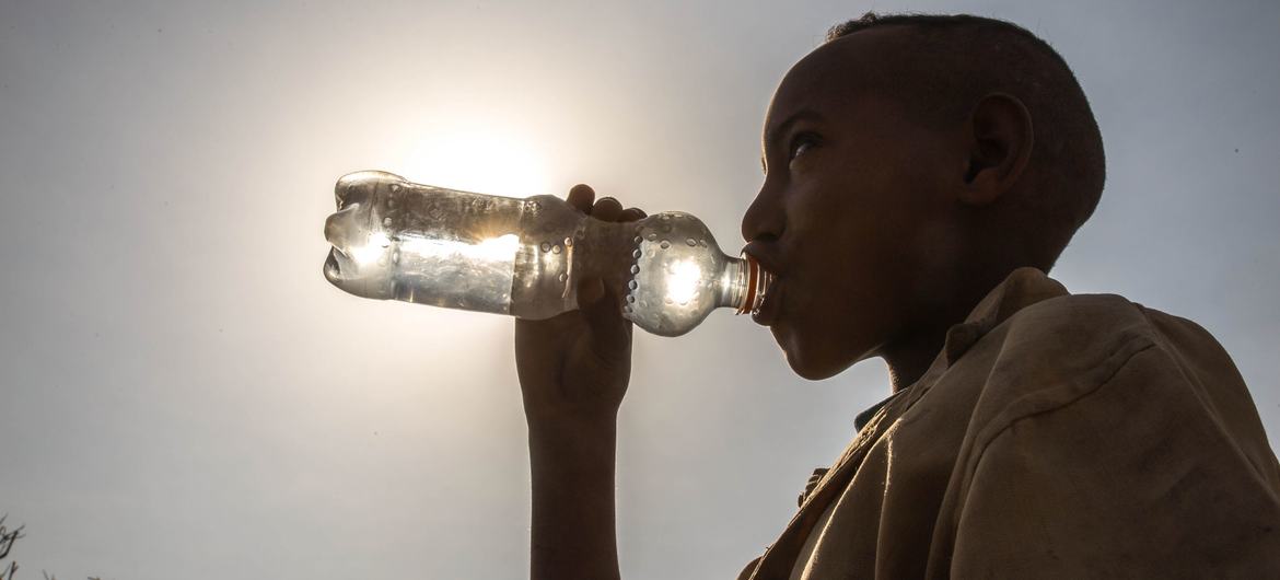 Uma criança bebe água de uma garrafa na Etiópia