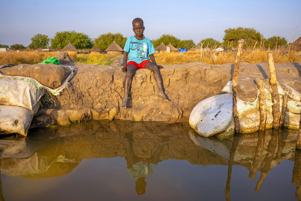 Un garçon assis près d'un champ inondé dans l'État de Jonglei, au Soudan du Sud.