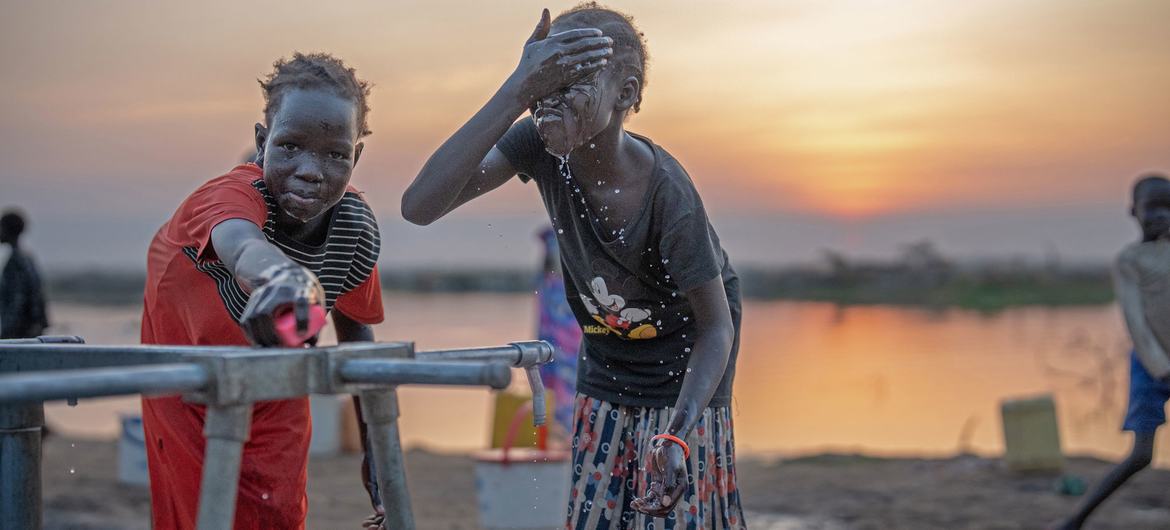 Meninas lavam-se em uma torneira em um campo para deslocados em Bentiu, Sudão do Sul