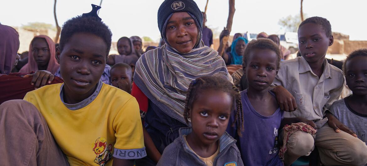 Un groupe d'enfants déplacés et de membres de leur famille sont assis ensemble dans un centre d'accueil à Tawila, dans le Darfour du Nord, au Soudan, après avoir fui la violence à Al Fasher.