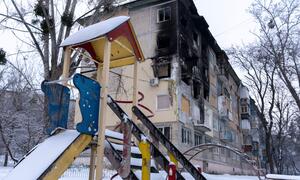 یوکرین کے شہر کیف میں اہم بنیادی ڈھانچے پر حملوں کے بعد شدید نقصان پہنچا رہائشی عمارت کے سامنے برف سے ڈھکا ہوا کھیل کا میدان کھڑا ہے۔ اس منظر میں موسم سرما کے دوران بچوں والے خاندانوں کو متاثر کرنے والے انسانی بحران پر روشنی ڈالی گئی ہے۔