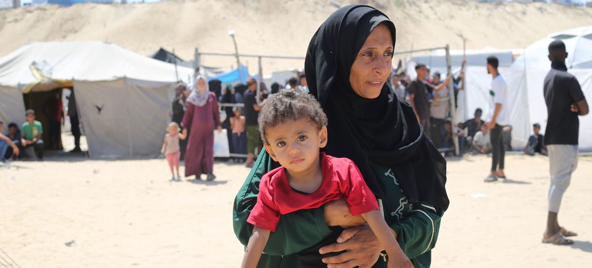 A mother holds her child in a camp for displaced people in Gaza. 