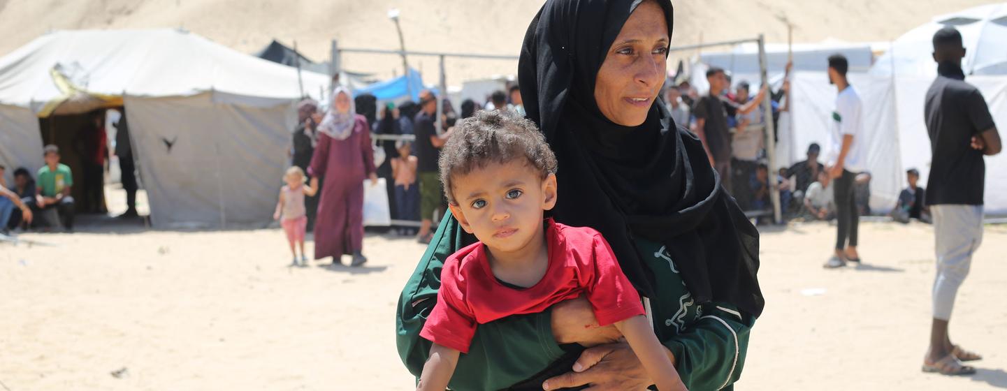 Une mère avec son enfant dans un camp de personnes déplacées à Gaza.