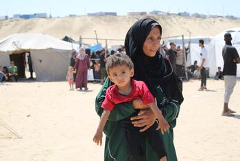 A mother holds her child in a camp for displaced people in Gaza. 