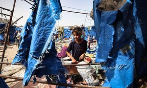 A young girl visits her tent which was destroyed following airstrikes in Deir al-Balah, Gaza.