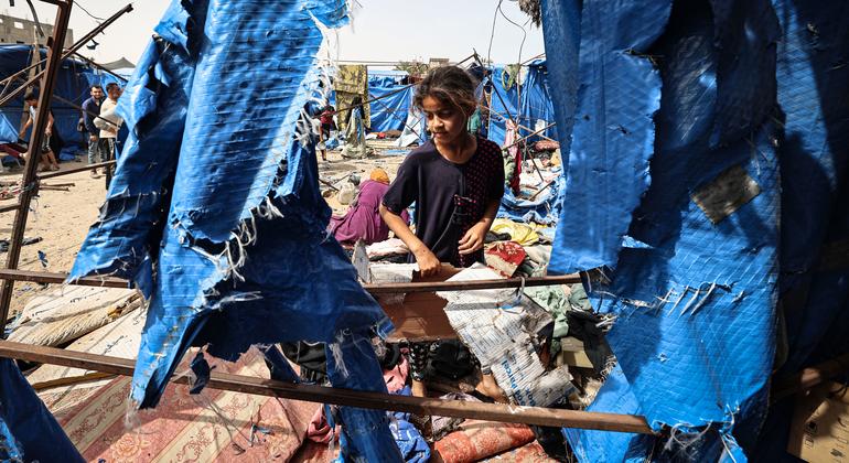 A young girl visits her tent which was destroyed following airstrikes in Deir al-Balah, Gaza.