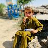 A primary school student in Zabul Province, Afghanistan, eats fortified biscuits provided by WFP. (file)