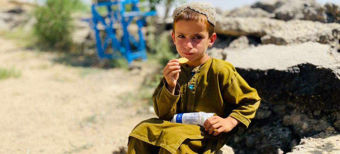 A primary school student in Zabul Province, Afghanistan, eats fortified biscuits provided by WFP (file)
