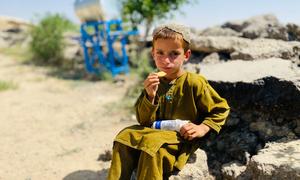 A primary school student in Zabul Province, Afghanistan, eats fortified biscuits provided by WFP (file)