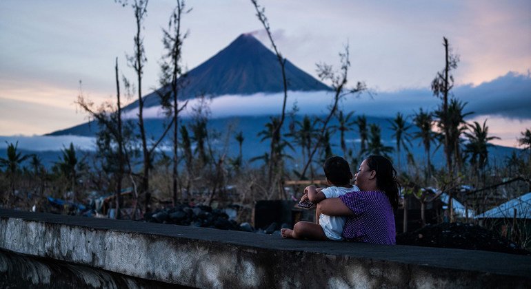 Família observa destruição causada por tufão nas Filipinas. 