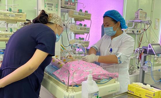 A woman checks on her newborn as a nurse monitors the baby's condition at a perinatal centre in Astana, Kazakhstan.