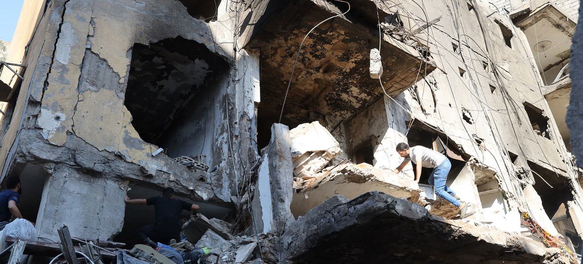 A man climbs over a destroyed building in the southern suburbs of Beirut, Lebanon.