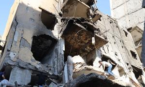 A man climbs over a destroyed building in the southern suburbs of Beirut, Lebanon.