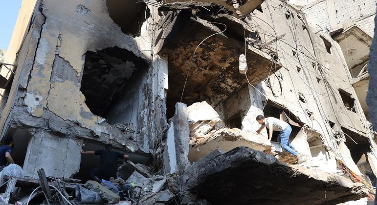 A man climbs over a destroyed building in the southern suburbs of Beirut, Lebanon.