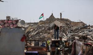 A Palestinian flag flies over the ruins of Khan Younis in the southern Gaza Strip.