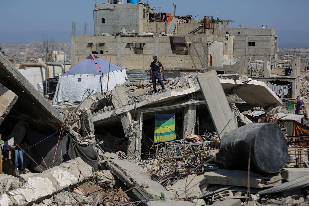 Un homme se tient sur un bâtiment détruit à Khan Younis, Gaza.