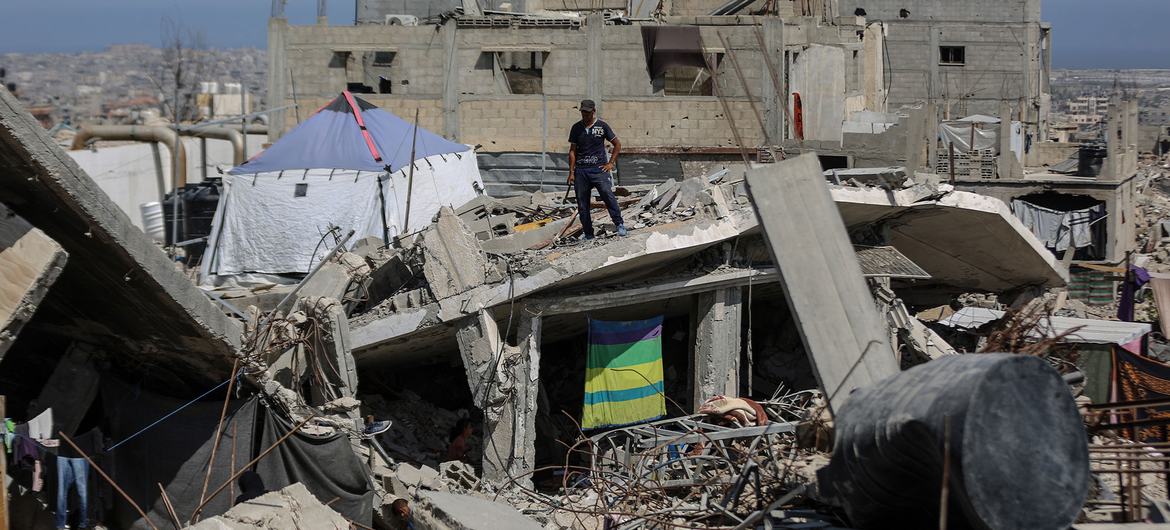 Un homme se tient sur un bâtiment détruit à Khan Younis, Gaza.