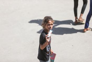 طفلة فلسطينية في خان يونس، جنوب غزة، ومعها طعام مقوى بمكملات غذائية موزع من وكالات الأمم المتحدة.