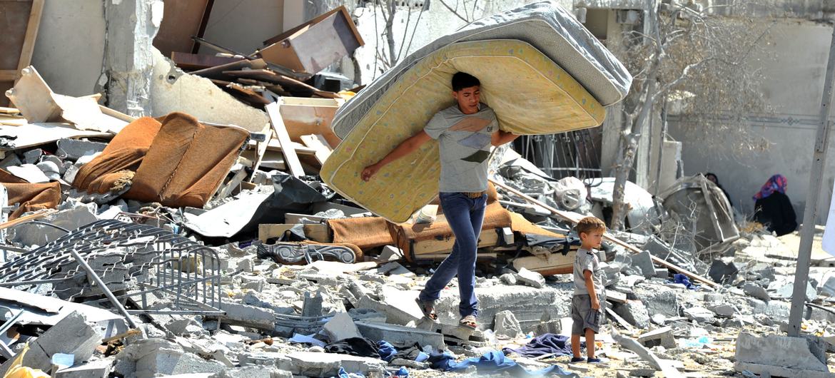 A Palestinian man salvages items from the rubble of a house destroyed by an Israeli attack on a building in the northern Gaza Strip in 2014. (file)