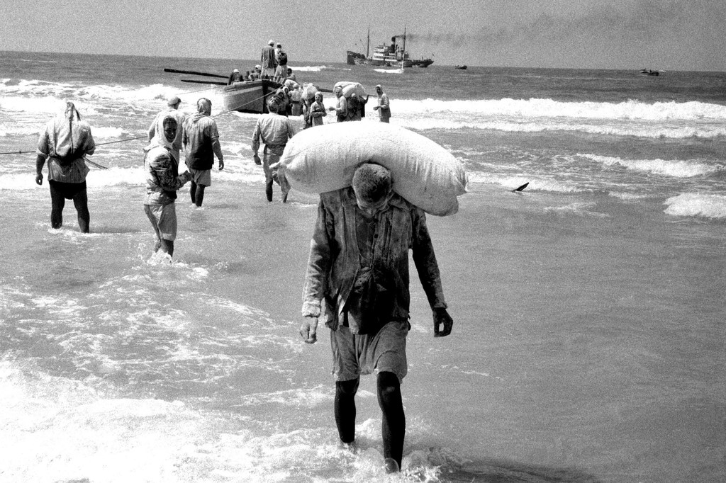 People in the Gaza Strip collect relief supplies delivered by boat in 1957. (file)