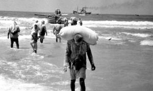 People in the Gaza Strip collect relief supplies delivered by boat in 1957. (file)