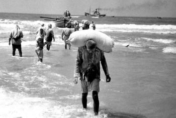 People in the Gaza Strip collect relief supplies delivered by boat in 1957. (file)