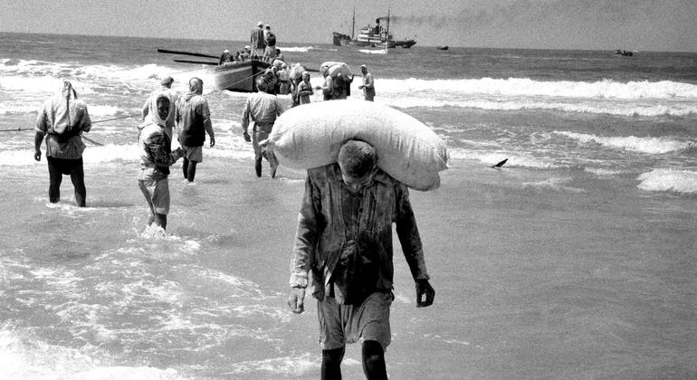 People in the Gaza Strip collect relief supplies delivered by boat in 1957. (file)