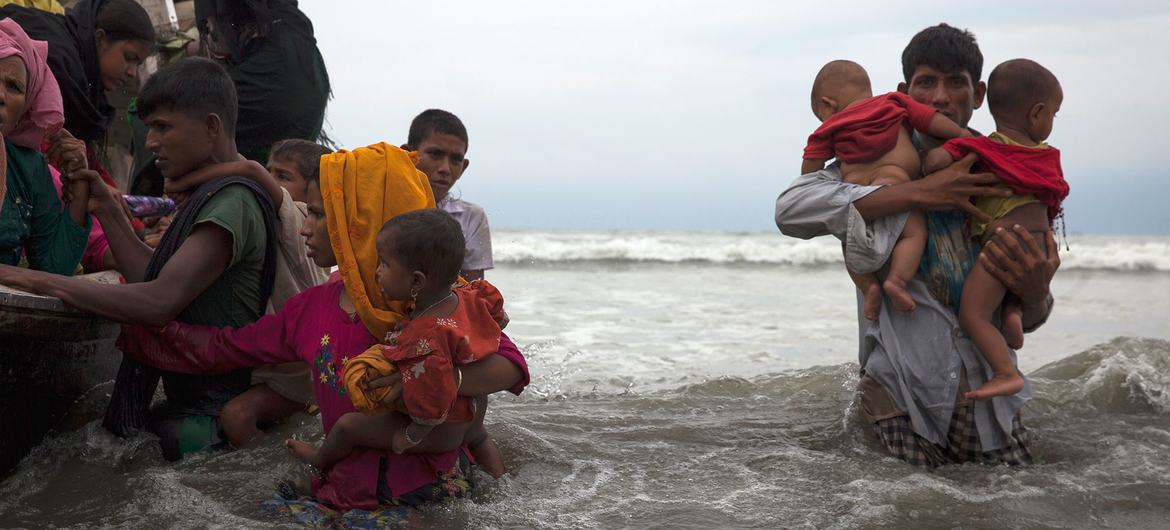 Refugiados rohinyá recién llegados caminan hacia la orilla en una playa del distrito de Cox's Bazar, en Bangladés, tras viajar durante cinco horas en una embarcación por las aguas abiertas del golfo de Bengala. (Foto de archivo)