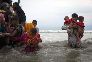 Newly arrived Rohingya refugees walk ashore at a beach in Cox's Bazar district, in Bangladesh, after travelling for five hours in a boat across the open waters of the Bay of Bengal. (file)