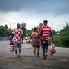 Members of a Haitian family return from the Dominican Republic carrying the few possessions they have.