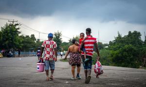 Members of a Haitian family return from the Dominican Republic carrying the few possessions they have.