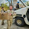 Irish and Polish UNIFIL peacekeepers in camouflage uniforms deliver aid boxes in Haddathah, south Lebanon.
