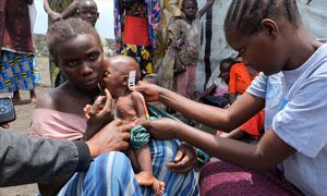 A malnourished child in the eastern DR Congo receives attention from a health worker.