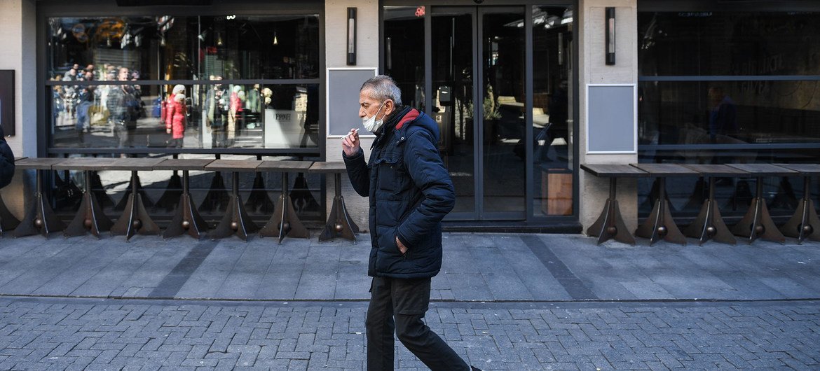 新冠疫情期间，一名男子在土耳其伊斯坦布尔街头抽烟。
