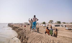 Children stand by a dike at a camp for people displaced by conflict in South Sudan. 